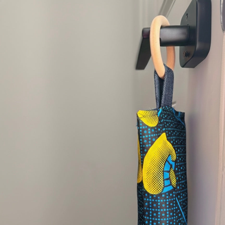 Entryway with a white door, wooden floor, and a blue draft stopper hanging from door knob